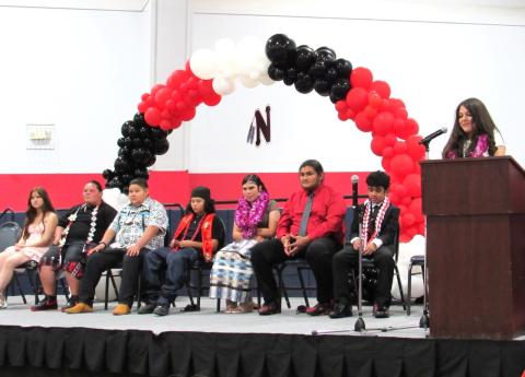 Victoria Boiso, at podium, speaks at the Noli Indian School 8th Grade Promotion, June 2. Seated from left are, Samantha Gladin, Tamara Hurtado, Harlow Ortiz, Tukwut Ortiz, Lylianna Procela Gemmell, Kenneth Razon, and Gabriel Romero Victoria Boiso, at podium, speaks at the Noli Indian School 8th Grade Promotion, June 2. Seated from left are, Samantha Gladin, Tamara Hurtado, Harlow Ortiz, Tukwut Ortiz, Lylianna Procela Gemmell, Kenneth Razon, and Gabriel Romero