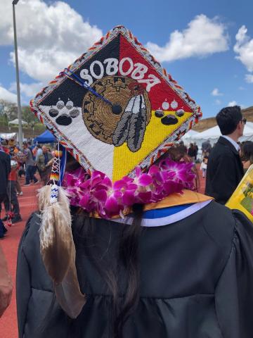 Rachelle Peterson proudly wears a mortarboard that carries traditional beadwork done by her mother, Michelle Morillo, and all the Eagle feathers her mother gifted her with from preschool promotion through college graduation from Cal State University, San Marcos on May 17 Rachelle Peterson proudly wears a mortarboard that carries traditional beadwork done by her mother, Michelle Morillo, and all the Eagle feathers her mother gifted her with from preschool promotion through college graduation from Cal State University, San Marcos on May 17