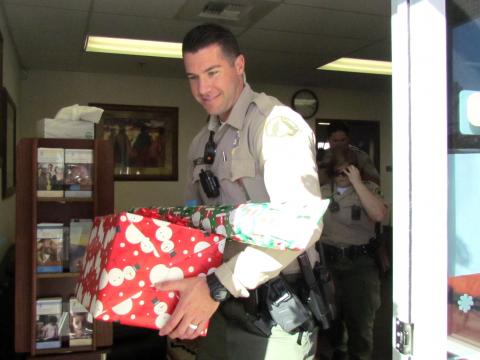 Riverside County Sheriff’s Department Deputy Trent Tully helps take Christmas gifts from the Soboba Tribal TANF office to members’ cars Riverside County Sheriff’s Department Deputy Trent Tully helps take Christmas gifts from the Soboba Tribal TANF office to members’ cars
