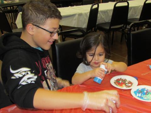 Samuel Graviloni, 12, helps two-year-old Rheya decorate a Christmas cookie during a Tribal Teen Night event on Dec. 19 Samuel Graviloni, 12, helps two-year-old Rheya decorate a Christmas cookie during a Tribal Teen Night event on Dec. 19