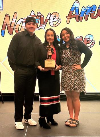 Geneva Mojado, center, shares her Warrior Award with her children, Daniel and Gloria at a ceremony on Dec. 1 Geneva Mojado, center, shares her Warrior Award with her children, Daniel and Gloria at a ceremony on Dec. 1