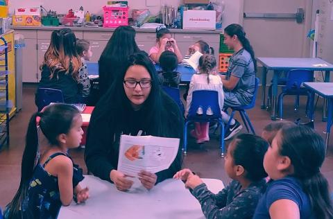 Vanessa Fernandez, front, shares her fable with kindergarten students while Frank Moreno reads his book to another group of students, back table Vanessa Fernandez, front, shares her fable with kindergarten students while Frank Moreno reads his book to another group of students, back table