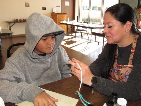 Instructor Kathy Lopez explains threading techniques to Christopher Lagunas during a recent beading workshop Instructor Kathy Lopez explains threading techniques to Christopher Lagunas during a recent beading workshop