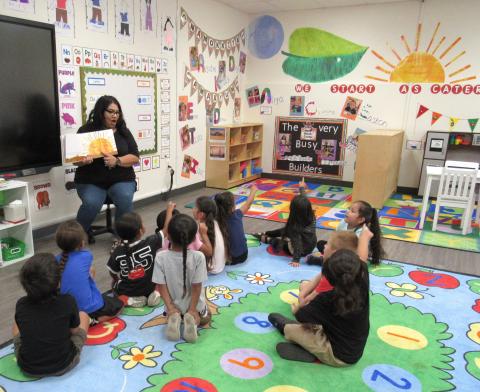 Pre-kindergarten teacher Ana Garcia interacts with students while reading “The Very Hungry Caterpillar” by asking them to find the sun on the classroom wall that matches the one in the book Pre-kindergarten teacher Ana Garcia interacts with students while reading “The Very Hungry Caterpillar” by asking them to find the sun on the classroom wall that matches the one in the book