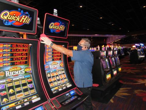 Soboba Casino Resort Environmental Services crew member Clyde Brotherton wipes down one of the casino’s 2,000 slot machines on May 22, in preparation for reopening Soboba Casino Resort Environmental Services crew member Clyde Brotherton wipes down one of the casino’s 2,000 slot machines on May 22, in preparation for reopening