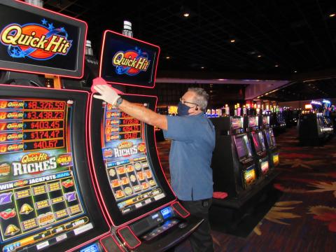 Soboba Casino Resort Environmental Services crew member Clyde Brotherton wipes down one of the casino’s 2,000 slot machines on May 22, in preparation for reopening
