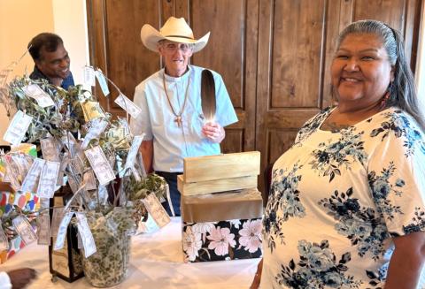 Father Earl Henley opens a special gift from Mia and Ruben Gonzalez at his farewell party, June 5 Father Earl Henley opens a special gift from Mia and Ruben Gonzalez at his farewell party, June 5