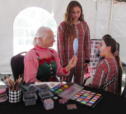 Face painter Greyzie gets a surprised reaction from Náanat Silvas, 9, as her sister Noyáaykit Silvas, 13, waits for her turn Face painter Greyzie gets a surprised reaction from Náanat Silvas, 9, as her sister Noyáaykit Silvas, 13, waits for her turn