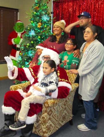Carrie Garcia and her extended family pose with Santa as the Grinch tries to sneak into the photo session Carrie Garcia and her extended family pose with Santa as the Grinch tries to sneak into the photo session