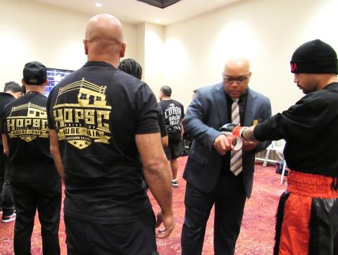 California State Athletic Commission athletic inspector Chi Montgomery tapes and signs the boxing gloves of Jimmie Nunez prior to his War in the Empire bout as his HOPSC coaches stand by. Photo courtesy of Soboba Band of Luiseño Indians California State Athletic Commission athletic inspector Chi Montgomery tapes and signs the boxing gloves of Jimmie Nunez prior to his War in the Empire bout as his HOPSC coaches stand by. Photo courtesy of Soboba Band of Luiseño Indians