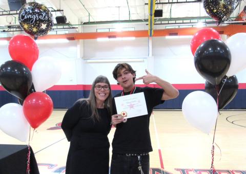 Teacher Jacquelin Phillips, who emceed the event, presents senior Edgar Gladin with an award for Excellence in Consumer Education Teacher Jacquelin Phillips, who emceed the event, presents senior Edgar Gladin with an award for Excellence in Consumer Education