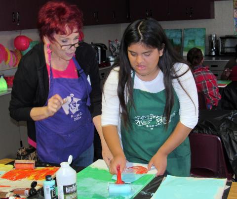 Artist Laura Ryan instructs Isabella Villegas on adding another layer to her sunflowers painting during a Count on Art class at West Valley High School Artist Laura Ryan instructs Isabella Villegas on adding another layer to her sunflowers painting during a Count on Art class at West Valley High School