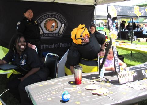 Soboba’s Department of Public Safety department gets into the theme of things with all things bees at the Earth Day event. Frankie Nicosia, center, wears a bee suit and poses with young guests behind the sweet handmade frame at their booth while his coworkers join in the fun Soboba’s Department of Public Safety department gets into the theme of things with all things bees at the Earth Day event. Frankie Nicosia, center, wears a bee suit and poses with young guests behind the sweet handmade frame at their booth while his coworkers join in the fun