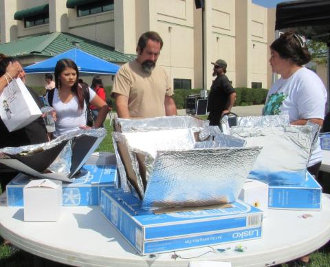 Noli science teacher Jay Dagostino, center, explains how his students created solar ovens that were on display to be voted on during the Earth Day event Noli science teacher Jay Dagostino, center, explains how his students created solar ovens that were on display to be voted on during the Earth Day event