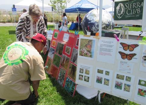A visitor to the Soboba Tribal Earth Day event on April 28 gets help from a Sierra Club representative to find the camouflaged creatures on a poster
