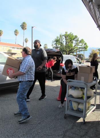 Vince Record, with boxes, Joseph Burton, center, and Cyndi Lemke, at cart, all lent a helping hand to distribute turkey dinners to needy families identified by Hemet Unified School District staff members Vince Record, with boxes, Joseph Burton, center, and Cyndi Lemke, at cart, all lent a helping hand to distribute turkey dinners to needy families identified by Hemet Unified School District staff members