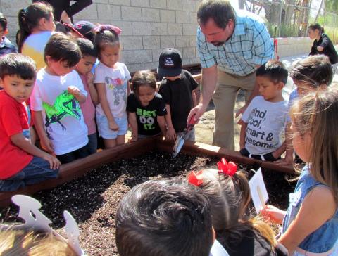 Noli Indian School science and agriculture teacher, Jay Dagostino, shows Soboba Tribal Preschool students how to plant seeds in their new raised bed garden on April 17 Noli Indian School science and agriculture teacher, Jay Dagostino, shows Soboba Tribal Preschool students how to plant seeds in their new raised bed garden on April 17