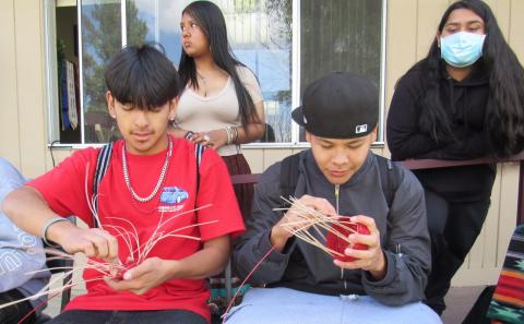 Michael Malone IV (Torres Martinez Band of Desert Cahuilla Indians), front left, and Brian Lagunas (Cahuilla Band of Cahuilla Indians) work on basket weaving while Nevaeh Ochoa, back left, and Tla’loc Galvan watch Michael Malone IV (Torres Martinez Band of Desert Cahuilla Indians), front left, and Brian Lagunas (Cahuilla Band of Cahuilla Indians) work on basket weaving while Nevaeh Ochoa, back left, and Tla’loc Galvan watch