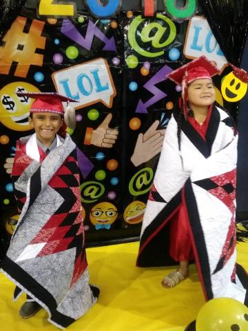 Kindergartners Ete’tish Suun Arviso, left and Tuupash Arivso take a photo opportunity with starburst quilts made by their great aunt Adela Morningstar Basquez Kolb and presented to them as graduation gifts Kindergartners Ete’tish Suun Arviso, left and Tuupash Arivso take a photo opportunity with starburst quilts made by their great aunt Adela Morningstar Basquez Kolb and presented to them as graduation gifts