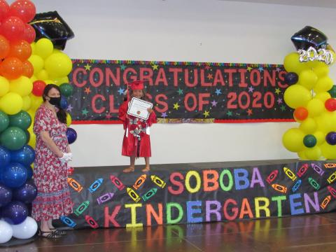 Tulóvat Teman receives her promotion certificate and awards as kindergarten teacher Cindy Lee looks on during the Soboba Tribal Preschool’s personalized graduation ceremonies on June 25 Tulóvat Teman receives her promotion certificate and awards as kindergarten teacher Cindy Lee looks on during the Soboba Tribal Preschool’s personalized graduation ceremonies on June 25
