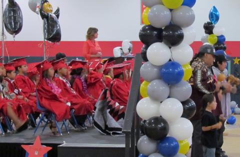 Pre-K students and director Dianne King listen as bird singers perform at their promotion ceremony on June 15 Pre-K students and director Dianne King listen as bird singers perform at their promotion ceremony on June 15