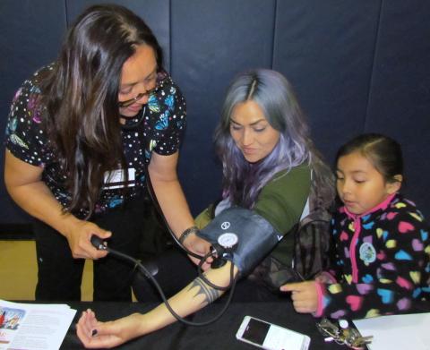 Noli Indian School nurse Camille Diaz takes the blood pressure of her daughter, Tekla, while Tekla’s niece watches Noli Indian School nurse Camille Diaz takes the blood pressure of her daughter, Tekla, while Tekla’s niece watches