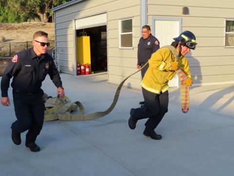 Jeremiah Ramos runs with the fire hose under the direction of Firefighter Thomas Ibarra, left, and Capt. Howard Maxcy Jr Jeremiah Ramos runs with the fire hose under the direction of Firefighter Thomas Ibarra, left, and Capt. Howard Maxcy Jr
