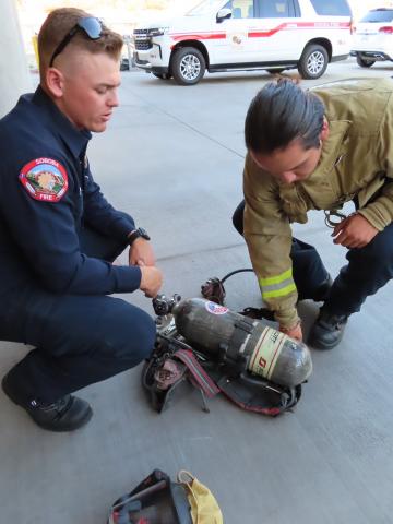 Firefighter Thomas Ibarra, left, oversees Soboba Fire Explorer Daniel Valdez Jr. as he checks out the air tank equipment before putting it on Firefighter Thomas Ibarra, left, oversees Soboba Fire Explorer Daniel Valdez Jr. as he checks out the air tank equipment before putting it on