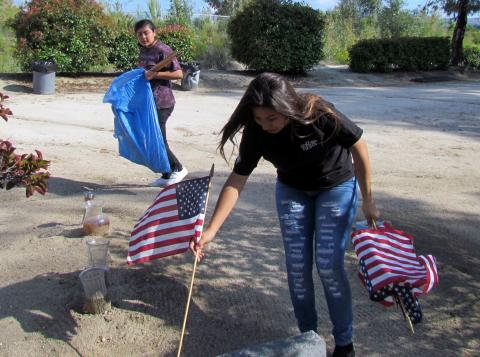 Ciara Ramos places a flag on a veteran’s grave as Iyana Briones carries more during a pre-Memorial Day event at the Soboba Cemetery Ciara Ramos places a flag on a veteran’s grave as Iyana Briones carries more during a pre-Memorial Day event at the Soboba Cemetery