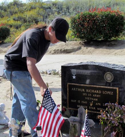 Arthur Lopez places a flag at the Soboba Cemetery grave of his grandfather, a Vietnam War veteran Arthur Lopez places a flag at the Soboba Cemetery grave of his grandfather, a Vietnam War veteran