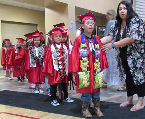 Graduates-to-be anxiously await entrance into the Soboba Sports Complex’s gymnasium with help from Pre-K teacher Ana Garcia Graduates-to-be anxiously await entrance into the Soboba Sports Complex’s gymnasium with help from Pre-K teacher Ana Garcia