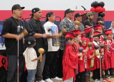 Wayne Nelson and the Intertribal Birdsingers are joined by kindergarten students as the June 3 ceremony begins Wayne Nelson and the Intertribal Birdsingers are joined by kindergarten students as the June 3 ceremony begins