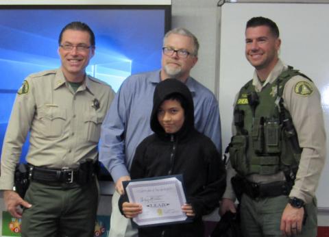 Riverside County Sheriff’s Office Captain Leonard Purvis, Soboba DPS Manager Brian Herritt and Deputy Sheriff Trent Tully pose with Julian Almada after his successful completion of the 12-week L.E.A.D. program at Noli Indian School Riverside County Sheriff’s Office Captain Leonard Purvis, Soboba DPS Manager Brian Herritt and Deputy Sheriff Trent Tully pose with Julian Almada after his successful completion of the 12-week L.E.A.D. program at Noli Indian School