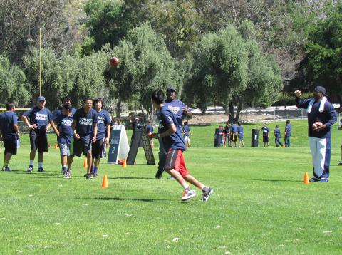 Rams alumni David Hill, center, and Reggie Doss, right, put Native American youth through skills drills during an NFL Play Football clinic at Soboba on Saturday Rams alumni David Hill, center, and Reggie Doss, right, put Native American youth through skills drills during an NFL Play Football clinic at Soboba on Saturday