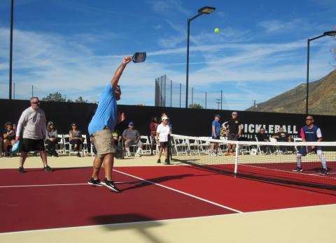 Jason Cozart makes a strong play as teammate Charles Berglund, left, referee Rosie Roper, center, pro Warren Tamanaha, right, and spectators watch during the inaugural pickleball game at the new stadium court Jason Cozart makes a strong play as teammate Charles Berglund, left, referee Rosie Roper, center, pro Warren Tamanaha, right, and spectators watch during the inaugural pickleball game at the new stadium court