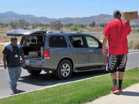 Nathaniel Arviso, left and Andy Silvas deliver USDA Farmers to Families Food Box Program produce to vehicles of tribal members on June 10 Nathaniel Arviso, left and Andy Silvas deliver USDA Farmers to Families Food Box Program produce to vehicles of tribal members on June 10