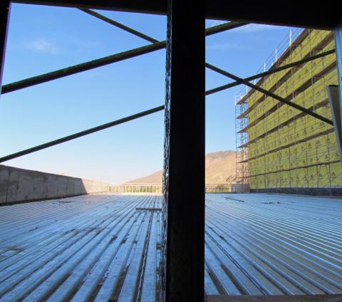 From a lower level perspective, the roof of the warehouse and shipping/receiving area can be seen as well as the back side of the replacement casino, at right, covered in gold DensGlass fiberglass mat gypsum sheathing used to protect structures against moisture damage during and after construction From a lower level perspective, the roof of the warehouse and shipping/receiving area can be seen as well as the back side of the replacement casino, at right, covered in gold DensGlass fiberglass mat gypsum sheathing used to protect structures against moisture damage during and after construction