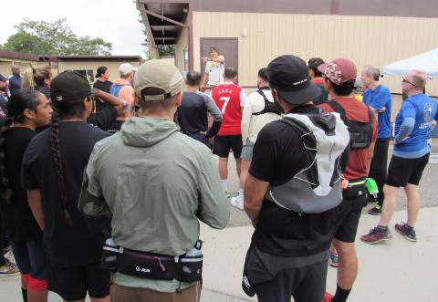 NATRO Founder and Race Director Sheldon Subith, center, gives pre-race instructions to runners before they start the race at Noli Indian School NATRO Founder and Race Director Sheldon Subith, center, gives pre-race instructions to runners before they start the race at Noli Indian School