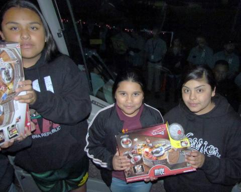 Soboba Tribal Youths help “Unstuff the Bus” of toys at the annual event of toy delivery to the San Jacinto Unified School District’s warehouse. From left, Su’la Arviso, Moyla Arviso and Tot Briones. About 200 community members waiting outside the bus to pass the toys along to reach the festively decorated warehouse on Nov. 26 can be seen through the bus’ windshield Soboba Tribal Youths help “Unstuff the Bus” of toys at the annual event of toy delivery to the San Jacinto Unified School District’s warehouse. From left, Su’la Arviso, Moyla Arviso and Tot Briones. About 200 community members waiting outside the bus to pass the toys along to reach the festively decorated warehouse on Nov. 26 can be seen through the bus’ windshield