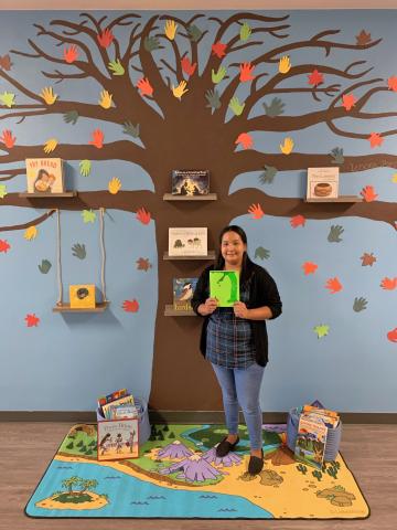Lenora “Ponie” Mojado stands in front of the tree she painted on the wall of the Soboba Tribal Preschool’s hallway. Shelves on the branches and swing hold books that have a Native American theme and she is holding one of her favorite storybooks: The Giving Tree by Shel Silverstein Lenora “Ponie” Mojado stands in front of the tree she painted on the wall of the Soboba Tribal Preschool’s hallway. Shelves on the branches and swing hold books that have a Native American theme and she is holding one of her favorite storybooks: The Giving Tree by Shel Silverstein