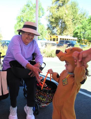Alice Helms shares candy with Scooby-Doo during the Soboba Tribal Preschool Trunk-or-Treat event on Halloween