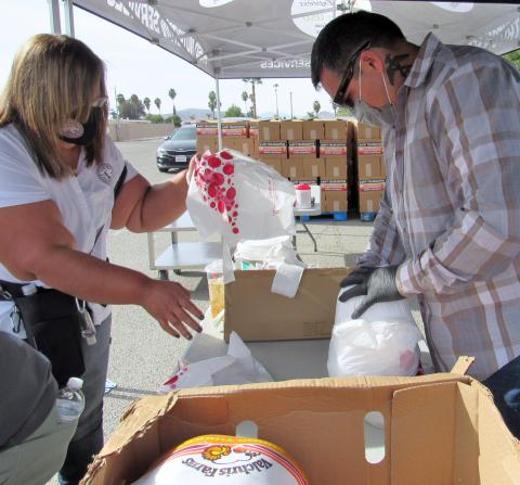 Soboba Foundation President Dondi Silvas, left, and Tribal Council Sergeant at arms Daniel Valdez, put 22-pound turkeys into plastic bags for easier distribution at HUSD on Nov. 20 during the Soboba Drive-Thru Turkey Giveaway Soboba Foundation President Dondi Silvas, left, and Tribal Council Sergeant at arms Daniel Valdez, put 22-pound turkeys into plastic bags for easier distribution at HUSD on Nov. 20 during the Soboba Drive-Thru Turkey Giveaway