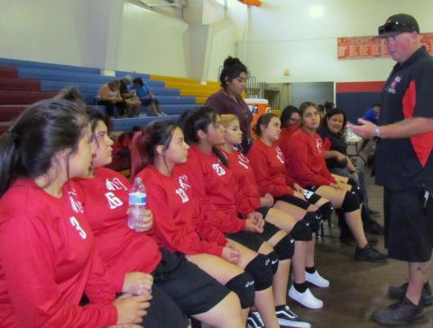 Assistant Coach Brian Savage gives some last-minute pointers to the volleyball team as Coach Andrea Helms-Sanchez (far right) and Alyssa Soza (standing) listen in, too Assistant Coach Brian Savage gives some last-minute pointers to the volleyball team as Coach Andrea Helms-Sanchez (far right) and Alyssa Soza (standing) listen in, too